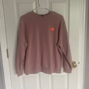 Pink crewneck with orange heart.